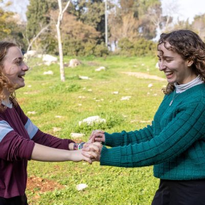 Two young women dancing outside