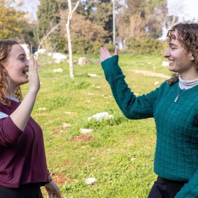 Two young women high-fiving outside 6