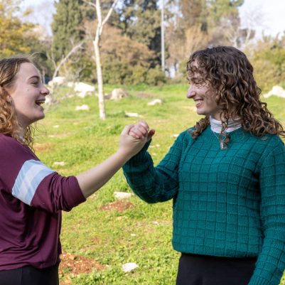 Two young women shaking hands