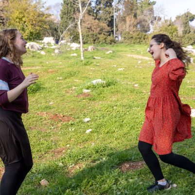 Two young women dancing in park 2