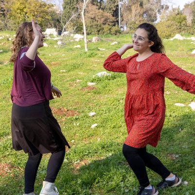 Two young women high-fiving outside 9