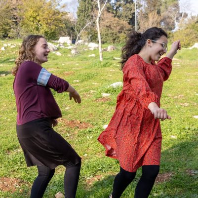Two young women dancing in park 3