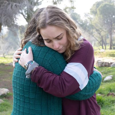 Two young women hugging