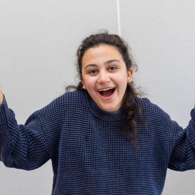 Young woman laughing and shrugging shoulders