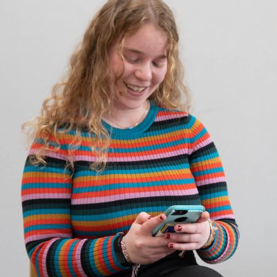 Young woman looking at phone smiling