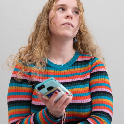 Young woman looking up from phone