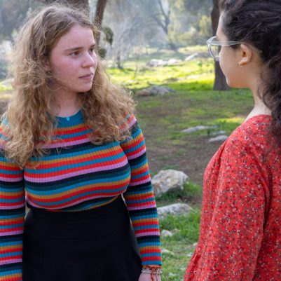 Two young women in serious conversation outside 2