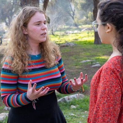 Two young women in serious conversation outside 3