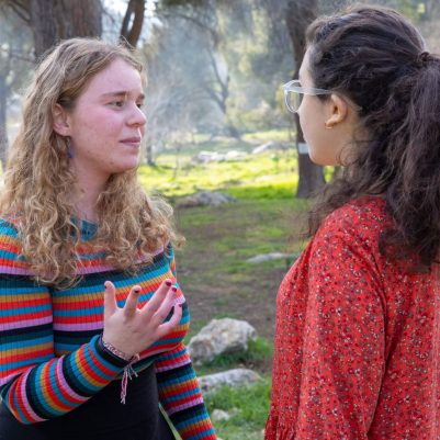 Two young women in serious conversation outside 4