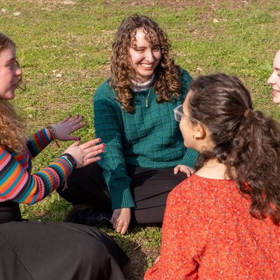 Group of young women sitting in a circle on grass 3