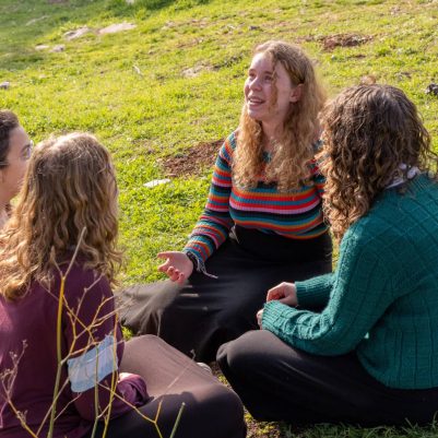 Group of young women sitting in a circle on grass 5