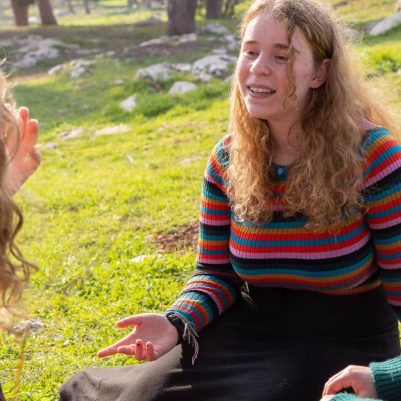 Young women sitting on grass talking 1