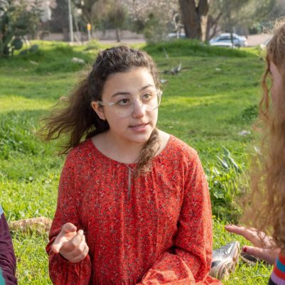 Young women sitting on grass talking 2