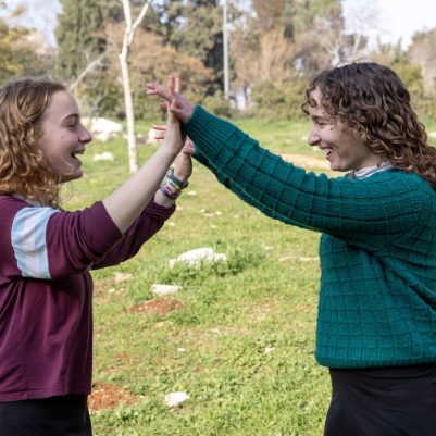 Two young women high-fiving outside 5