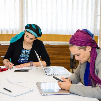 Businesswomen taking notes during meeting