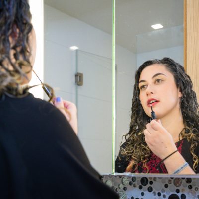 Woman putting on lip gloss