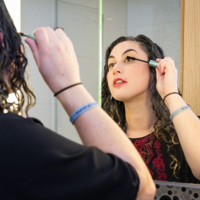 Woman putting on mascara