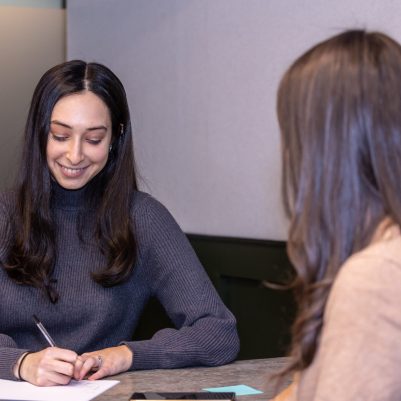 Businesswoman taking notes at meeting 1