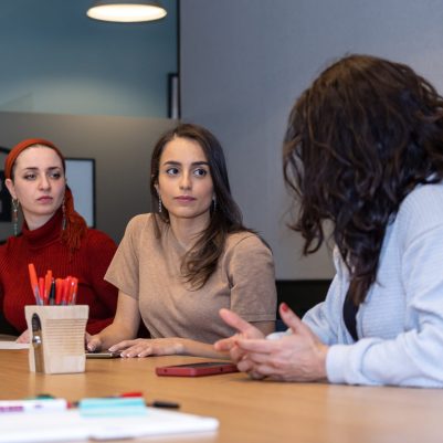 Businesswomen listening to colleague at meeting 1