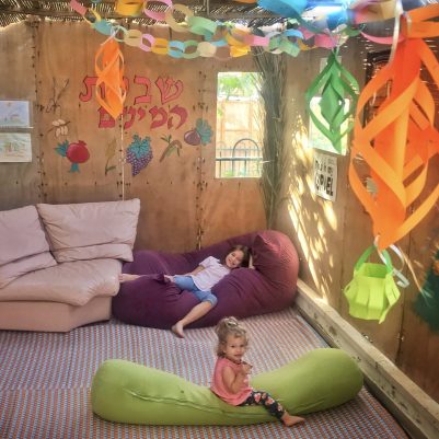 Two girls sitting in Sukkah