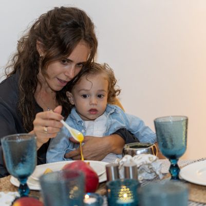 Mother holding baby at Rosh Hashana table