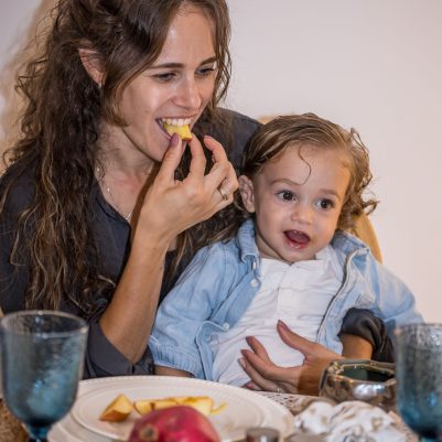 Mother and baby dipping apple in honey 2