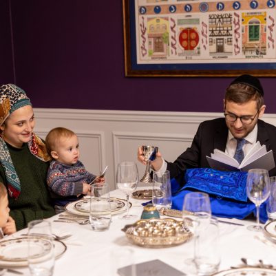 Father sitting making kiddush with family