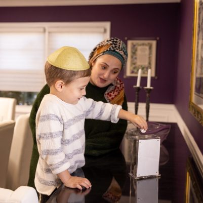Mother watching son give Tzedakah 2