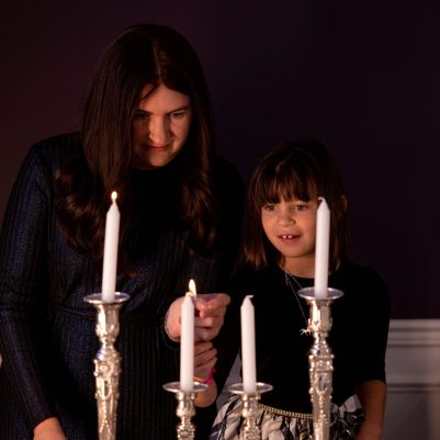 Mother and daughter lighting candles 2