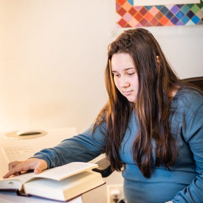 Young woman reading book at desk 1