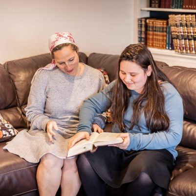 Mother and daughter sitting on couch learning 1