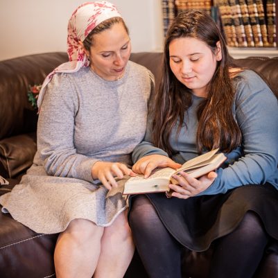 Mother and daughter sitting on couch learning 2