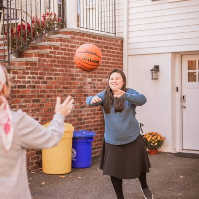 Young woman throwing basketball to mother