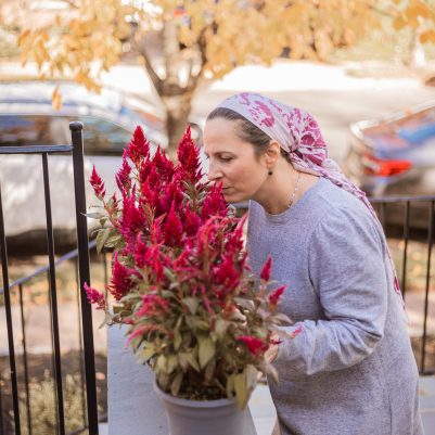 Woman smelling flowers on porch 2
