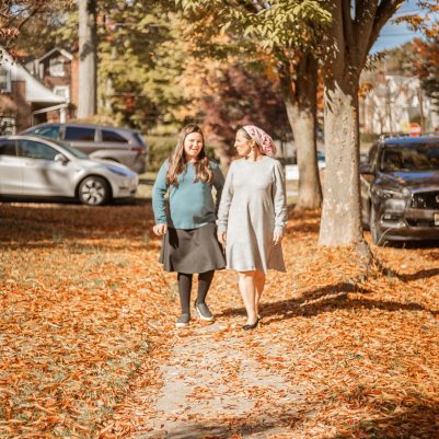 Mother and daughter walking on sidewalk 1