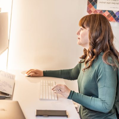 Woman sitting at desk looking at computer 1