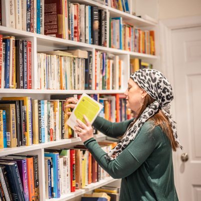 Woman returning book to shelf 2