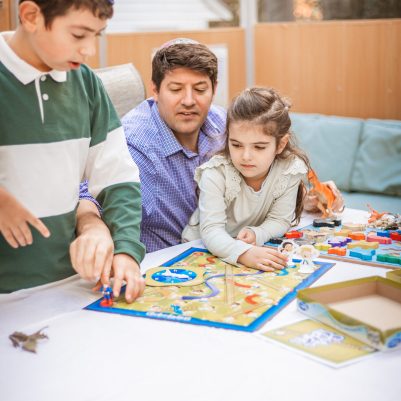 Family playing board game in Sukkah 1