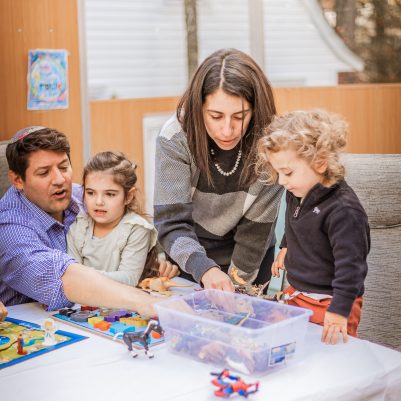 Family playing board game in Sukkah 3