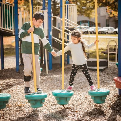 Brother and Sister playing on jungle gym 1