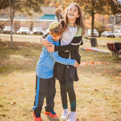 Brother and sister hugging and laughing