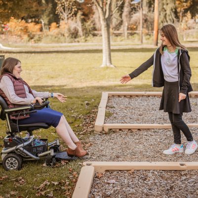 Woman in wheelchair and girl at park 1