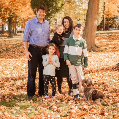 Family smiling at park with leaves on ground 1