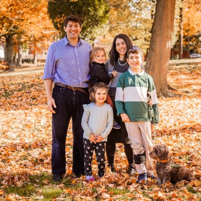 Family smiling at park with leaves on ground 3