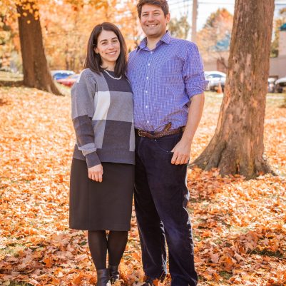 Couple smiling at park with leaves on ground 2