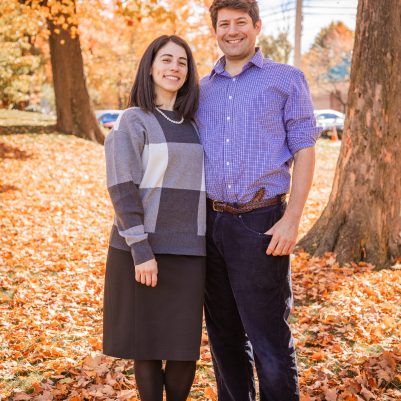 Couple smiling at park with leaves on ground 3