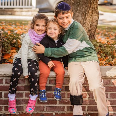 Smiling siblings sitting outside