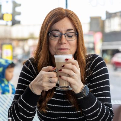 Smiling woman drinking coffee at restaurant 2