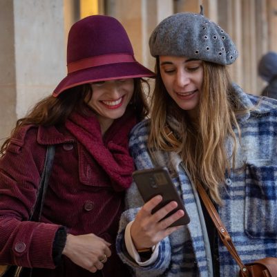 Two smiling women looking at phone 1