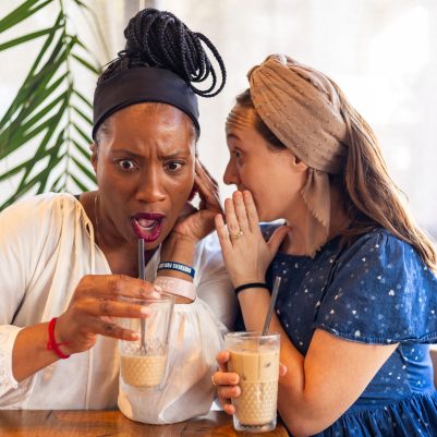 Woman whispering to friend 1